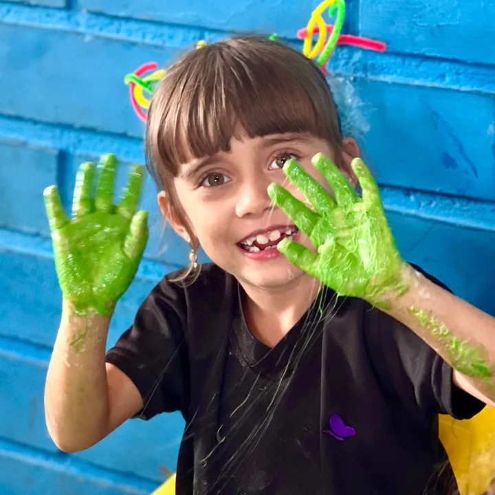 Niña de preescolar pintando con las manos